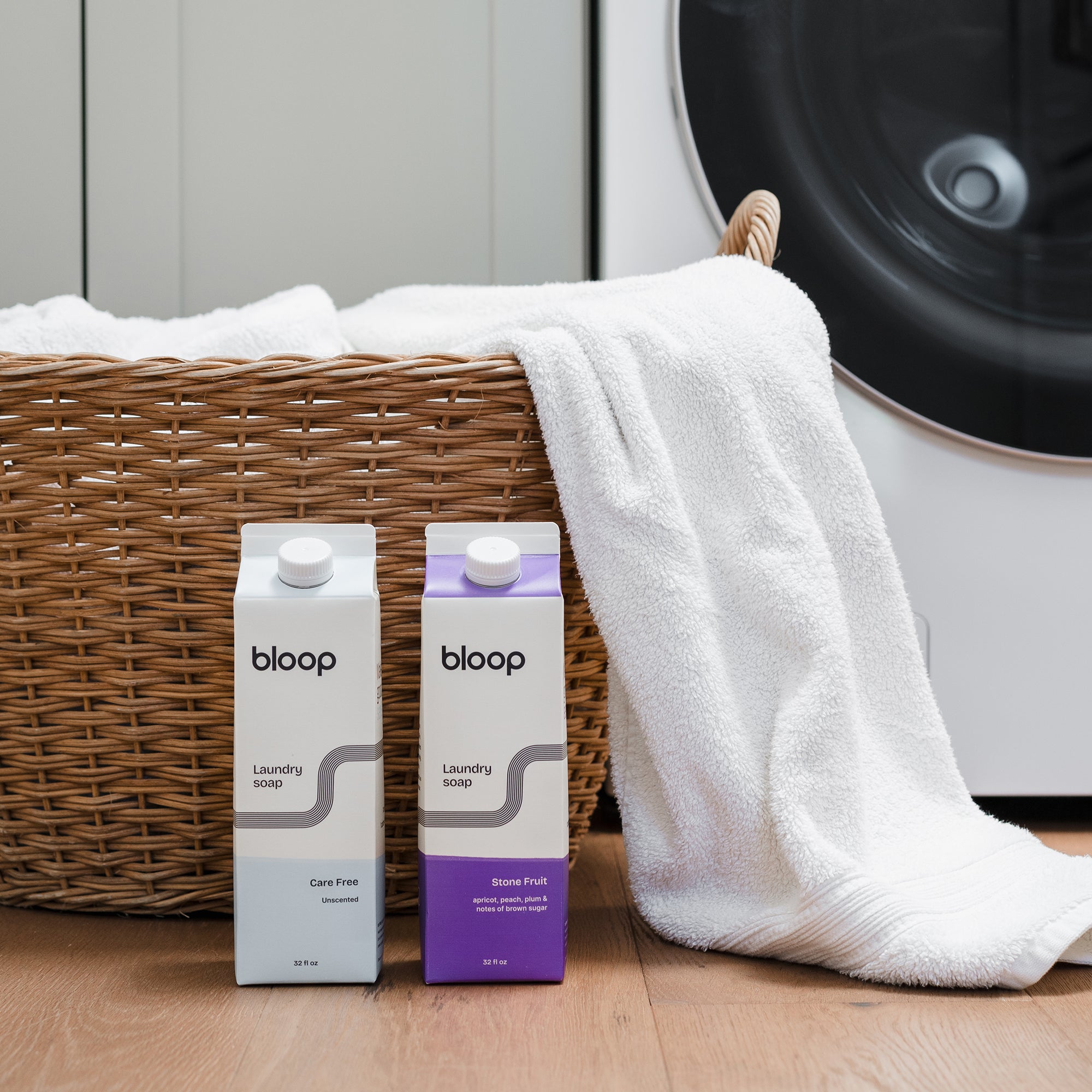 Front View of Care Free and Stone Fruit Concentrated Laundry Soap. 32 ounces each. Plastic-free. Product in front of laundry room.