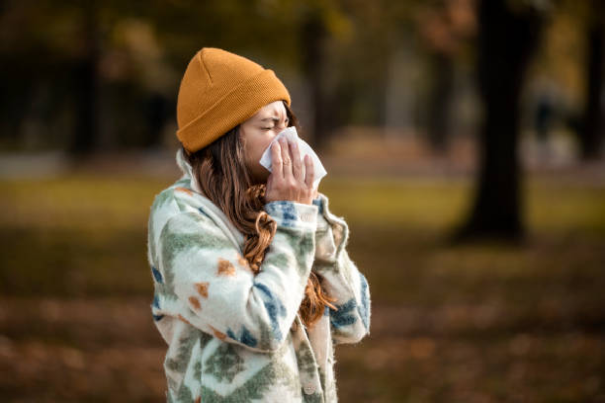 Woman blowing nose due to fall allergies pollen and mold. Bloop natural laundry soap helps break these down. 