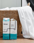 Two Cartons of Salt Air Laundry Soap, front view and side view. 32 ounces. Plastic-free. Laundry basket behind product.