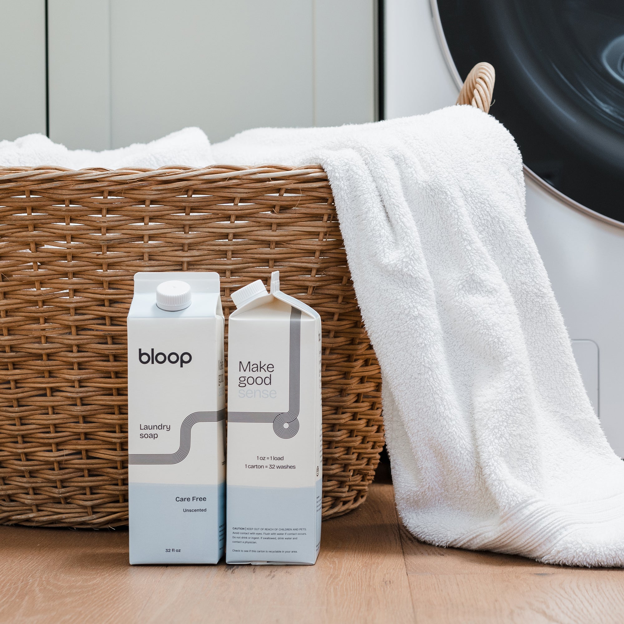 Two Cartons of Care Free Laundry Soap, front view and side view. 32 ounces. Plastic-free. Laundry basket behind product.